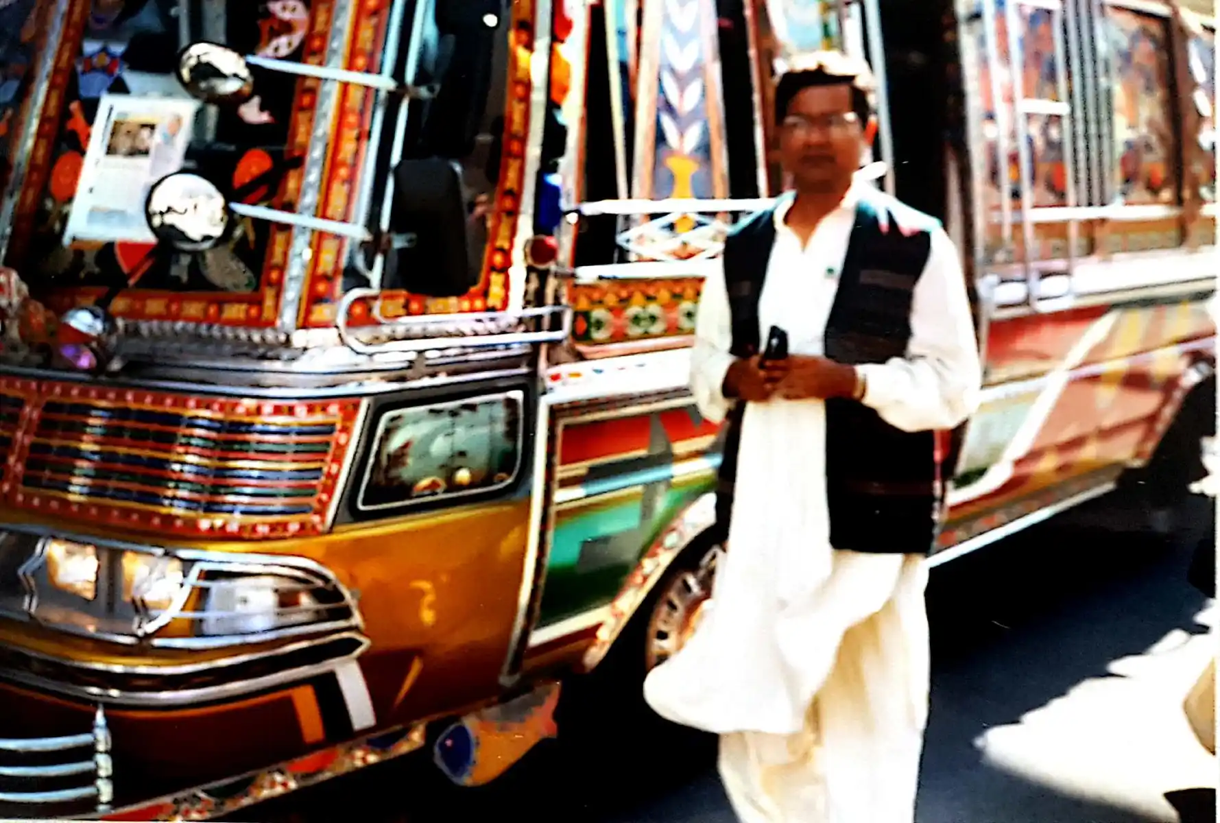 Abbildung-pakistanischer-Besucher-der-expo-in-hannover-im-jahr-2000-vor-einem-traditionellen-pakistanischen-Transportbus-IISW